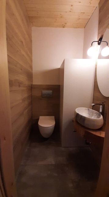 Bieszczady - Domek nad stawem - Mała łazienka z WC, umywalka i drewniany blat.
